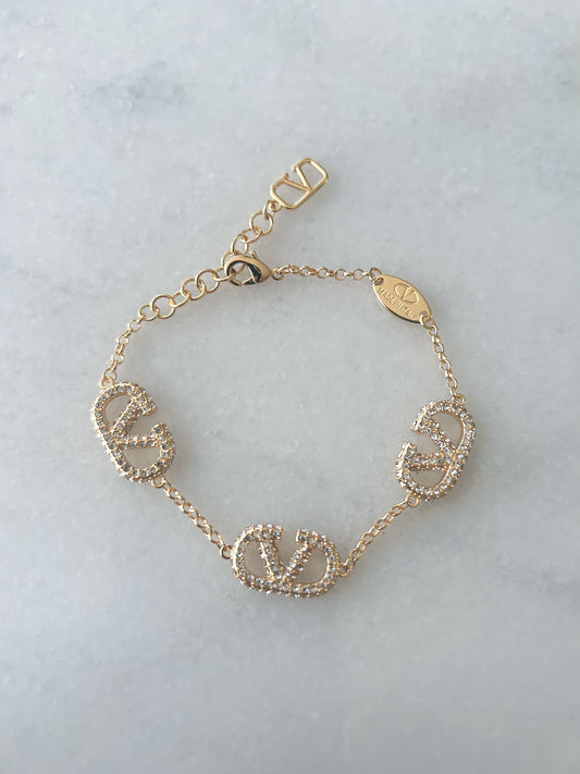 Gold Valentino Garavani inspired bracelet with sparkling diamantés and elegant polished finish.
