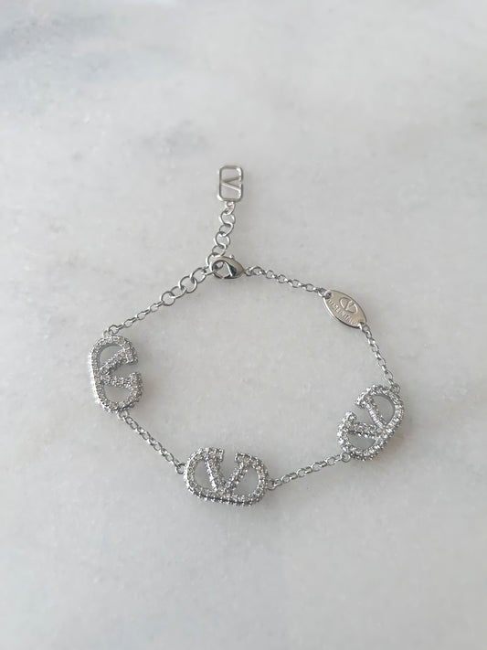 Silver V logo bracelet for women with sparkling diamanté stones, modern minimalist design, elegant fashion jewelry on a polished silver chain.