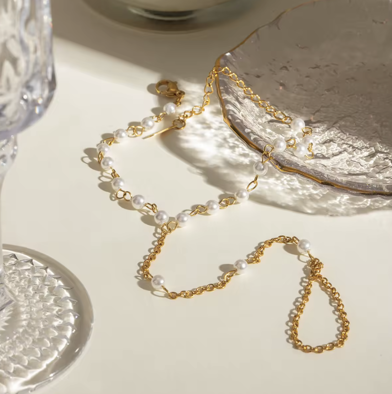 Gold-dipped stainless steel Pearly Link Bracelet featuring lustrous imitation pearls, connected by a delicate chain linking a ring and bracelet; elegant, feminine, and modern jewelry design