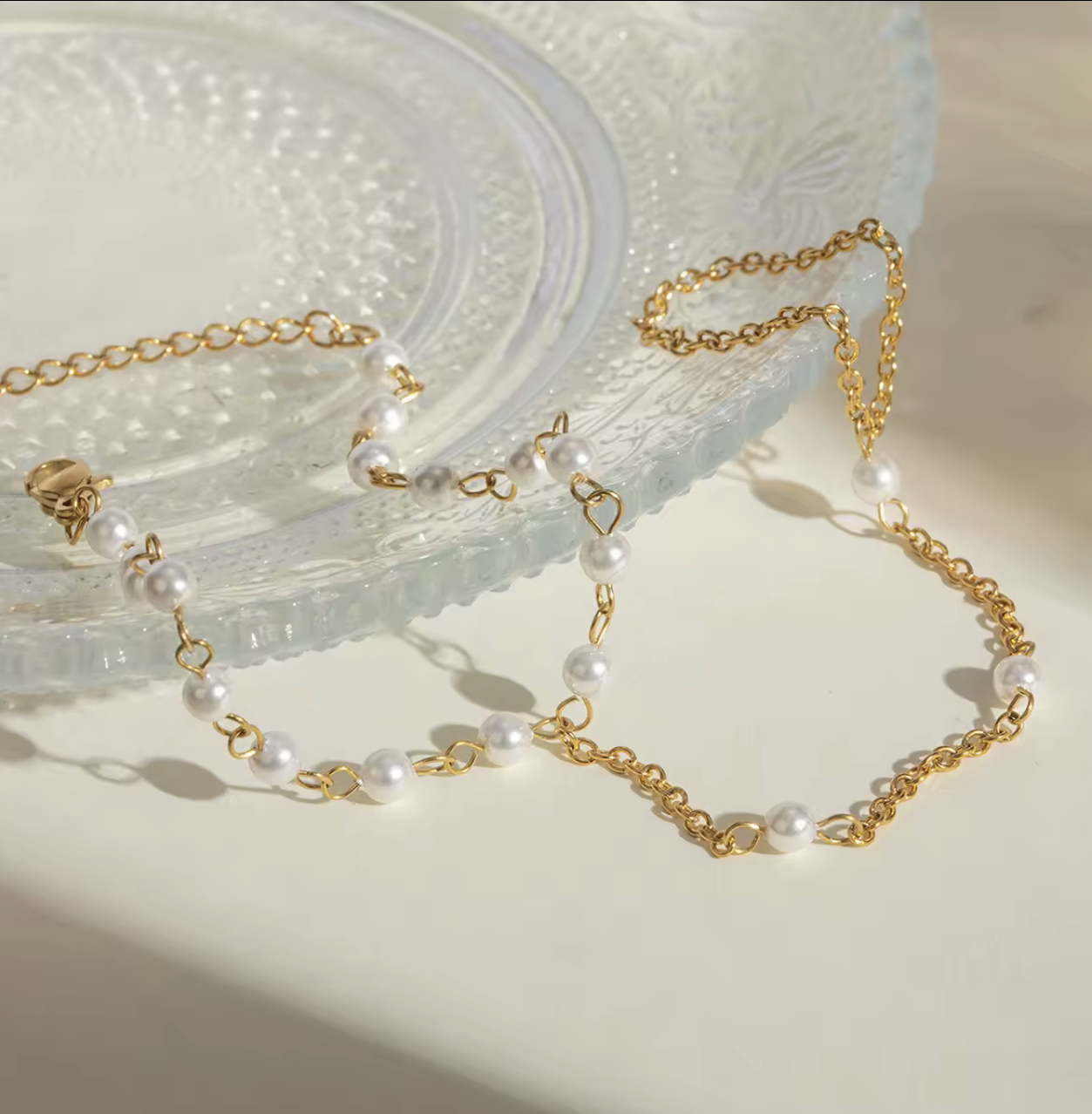 Gold-dipped stainless steel Pearly Link Bracelet featuring lustrous imitation pearls, connected by a delicate chain linking a ring and bracelet; elegant, feminine, and modern jewelry design