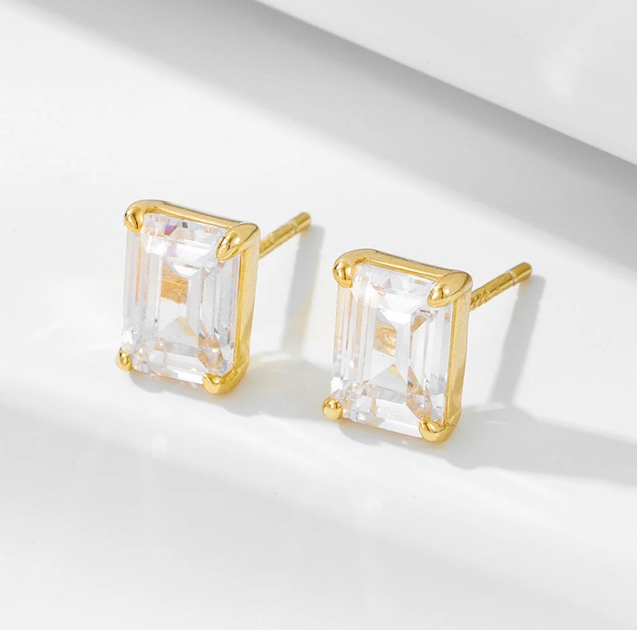 Infuse your daily wardrobe with a sense of timeless elegance with The Emerald-Cut Studs. Inspired by the grandeur of Art Deco design, these earrings feature a striking rectangular silhouette that emphasizes clarity and sophisticated geometry. The stepped facets of the emerald-cut stones catch the light with a subtle, hall-of-mirrors effect, offering a refined sparkle that is both understated and undeniably luxurious.