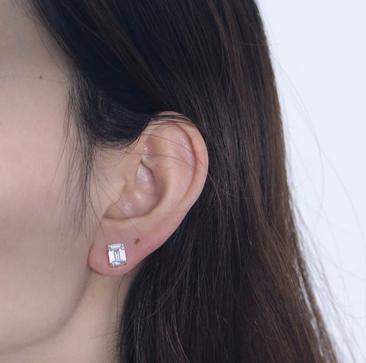 Infuse your daily wardrobe with a sense of timeless elegance with The Emerald-Cut Studs. Inspired by the grandeur of Art Deco design, these earrings feature a striking rectangular silhouette that emphasizes clarity and sophisticated geometry. The stepped facets of the emerald-cut stones catch the light with a subtle, hall-of-mirrors effect, offering a refined sparkle that is both understated and undeniably luxurious.