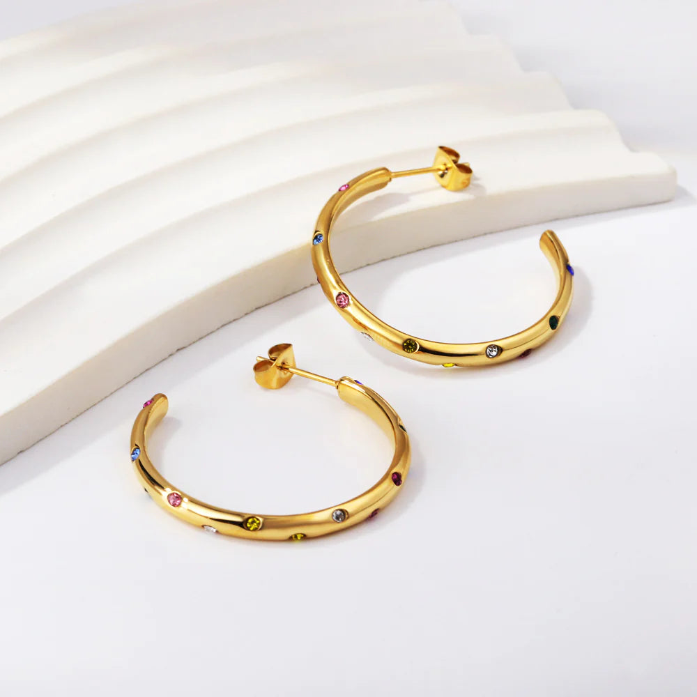 Elevate your style with a front view of our "Celestial" Hoop Earrings, showcasing the intricate design of multicolor diamond stimulant dots against the radiant 18k gold-plated stainless steel.  Explore the side profile of our "Celestial" Hoop Earrings, highlighting the lightweight and comfortable construction, ensuring a seamless fit for any occasion.