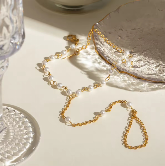 Gold-dipped stainless steel Pearly Link Bracelet featuring lustrous imitation pearls, connected by a delicate chain linking a ring and bracelet; elegant, feminine, and modern jewelry design