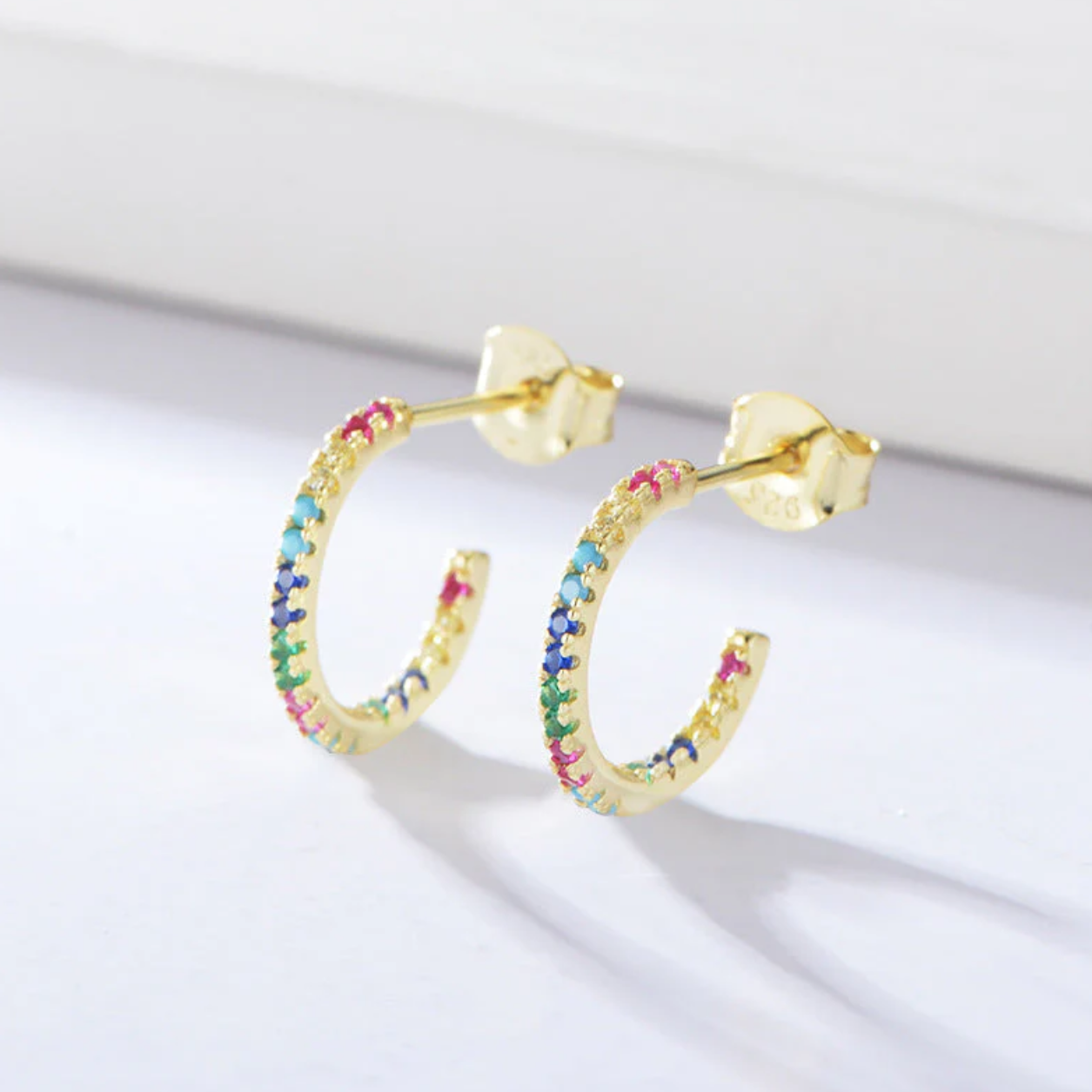 The Colour Drop Mini Hoop

Add a refined pop of colour to your everyday look with The Colour Drop Mini Hoop, a pair of elegant gold mini hoop earrings designed to sparkle effortlessly. Crafted from premium 925 sterling silver and finished with 18K gold PVD plating, these earrings offer lasting brilliance with a luxurious, modern feel.