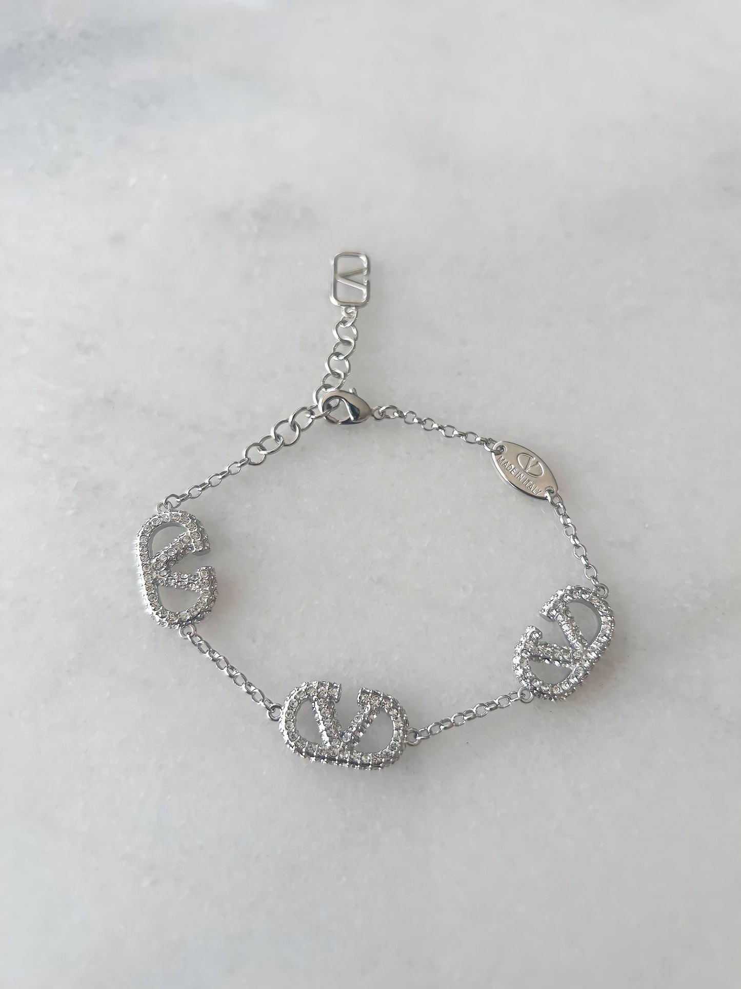 A sterling silver bracelet with multiple diamond accents, displayed against a white background.