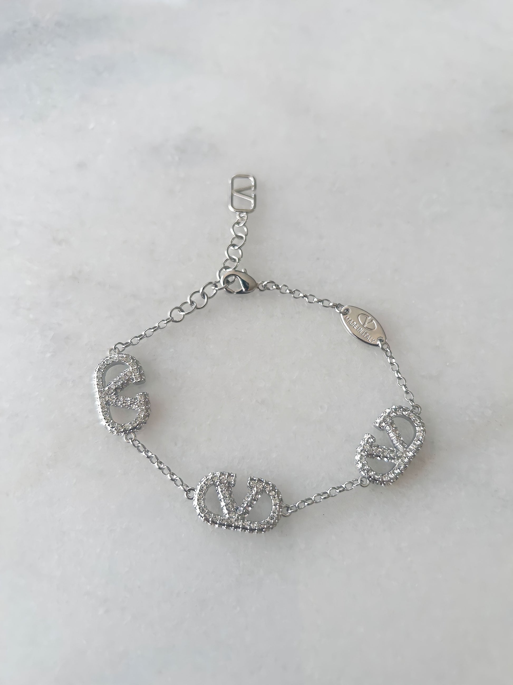 A sterling silver bracelet with multiple diamond accents, displayed against a white background.